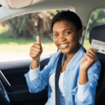 Happy young learner's license recipient proudly holding her driver's license.